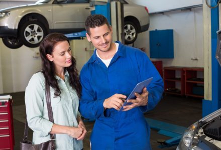 Mechanic showing tablet pc to customer at the repair garage